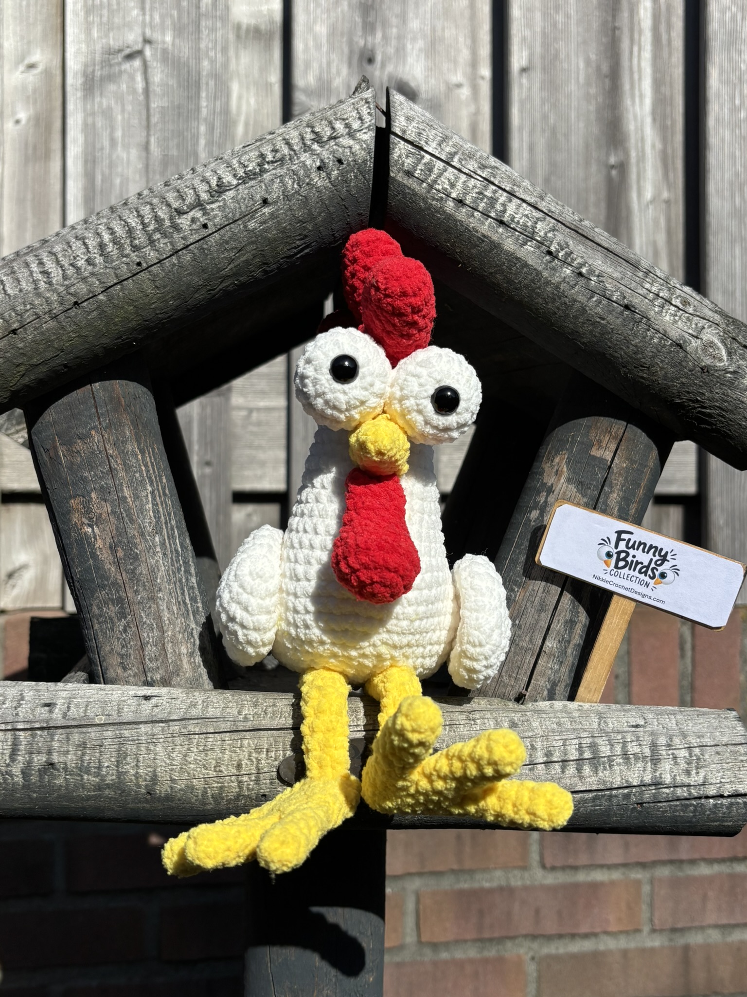 Cheeky Chicken perched in a wooden bird feeder
